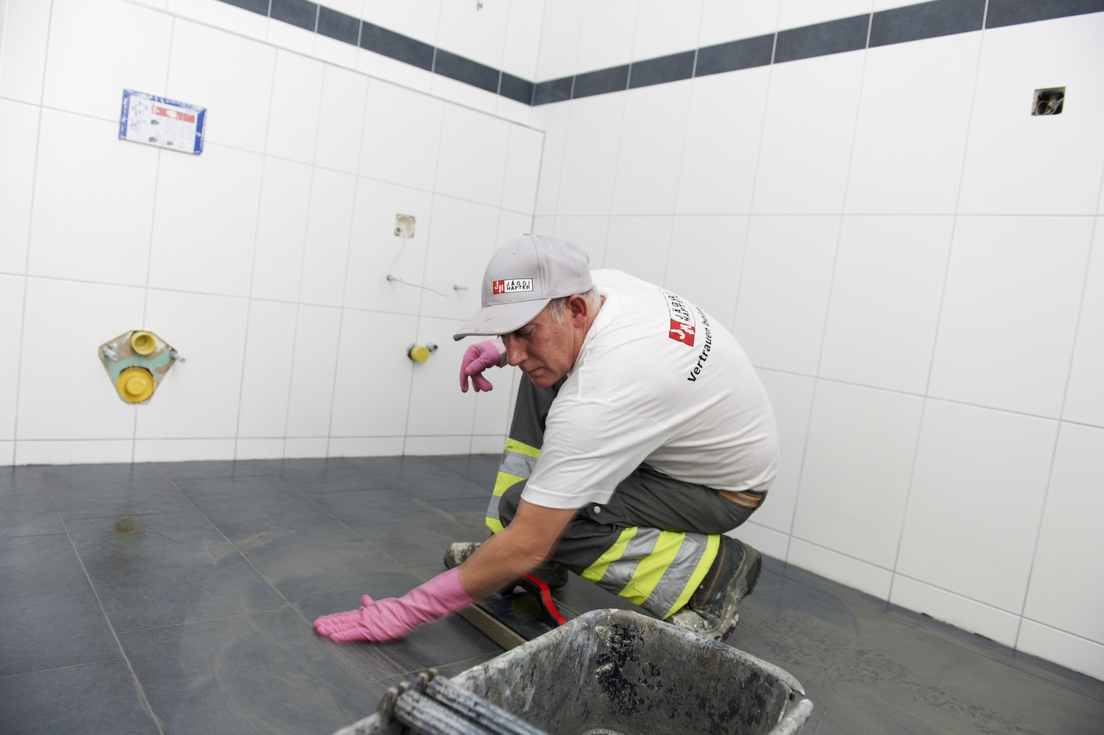 Handwerker beim Verfugen von Bodenfliesen
