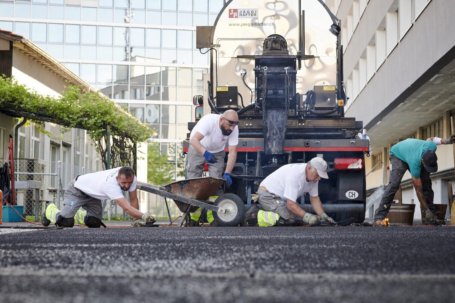 4 Männer vor Lastwagen verarbeiten Gussasphalt